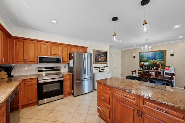 kitchen featuring appliances with stainless steel finishes, pendant lighting, brown cabinets, and ornamental molding