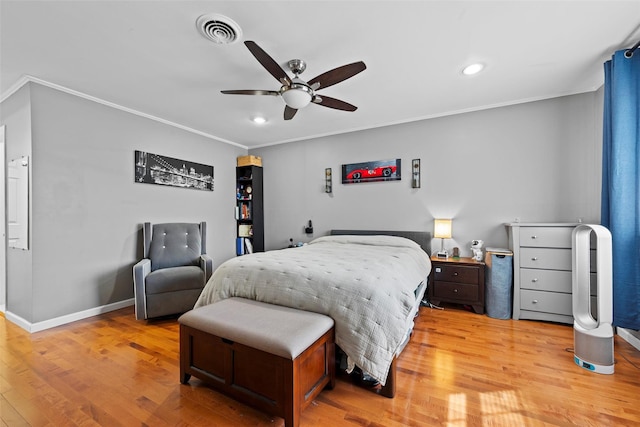 bedroom featuring light wood-style floors, baseboards, visible vents, and crown molding