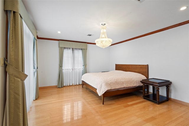 bedroom with a notable chandelier, visible vents, ornamental molding, light wood-type flooring, and baseboards