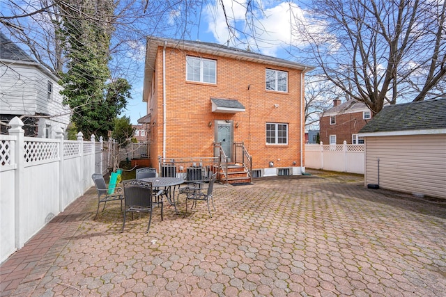 rear view of house with a patio area, a fenced backyard, cooling unit, and brick siding