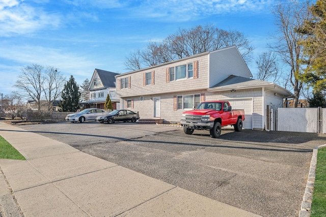 view of front of home featuring an attached garage, a gate, and fence