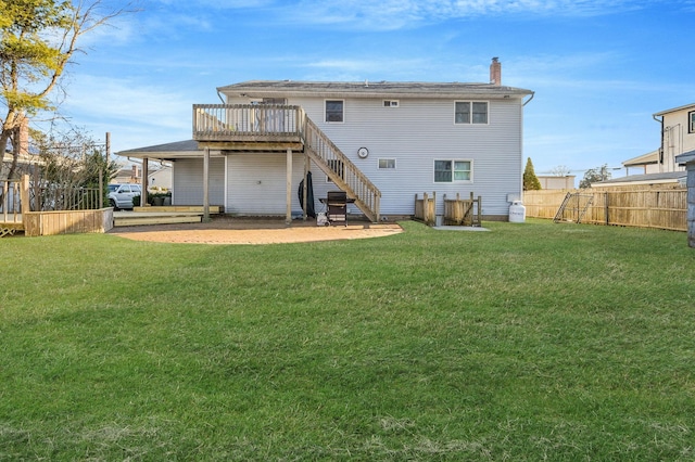 rear view of house with fence, stairway, a lawn, and a wooden deck