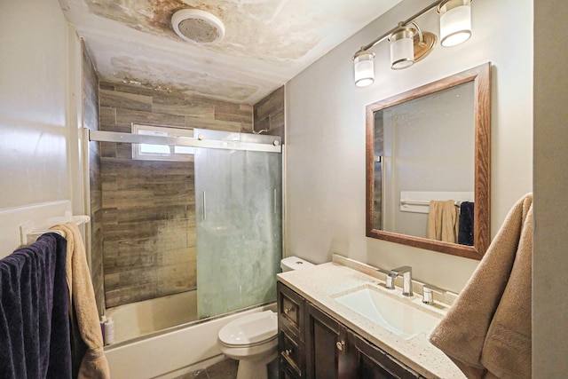 full bathroom with toilet, bath / shower combo with glass door, and vanity