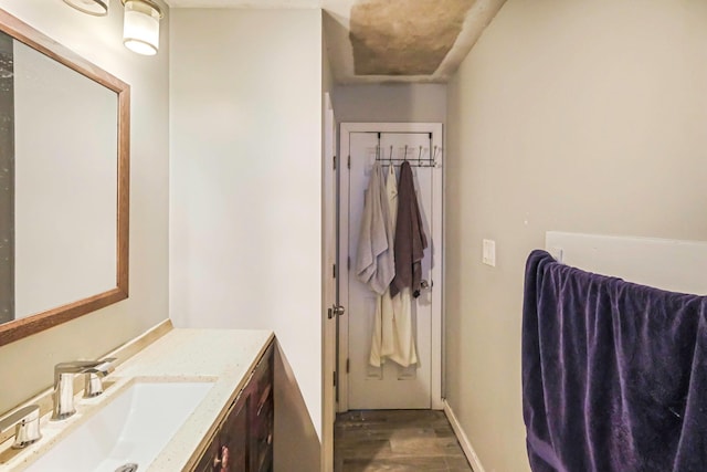 bathroom featuring vanity, baseboards, and wood finished floors