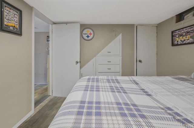 bedroom with dark wood-type flooring and baseboards