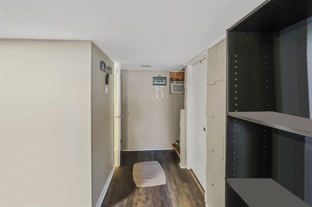 hall with dark wood-style floors, baseboards, and a wall mounted AC