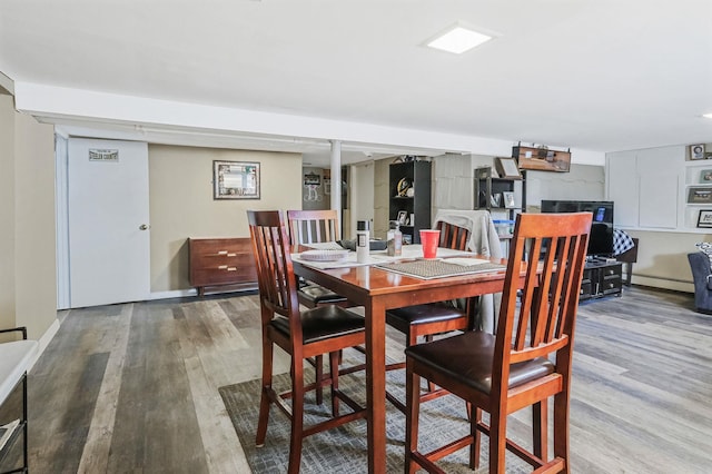 dining room featuring a baseboard radiator and wood finished floors