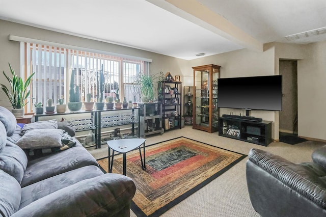 carpeted living room with visible vents and beamed ceiling