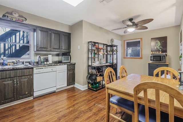 dining room with a ceiling fan, visible vents, baseboards, and wood finished floors