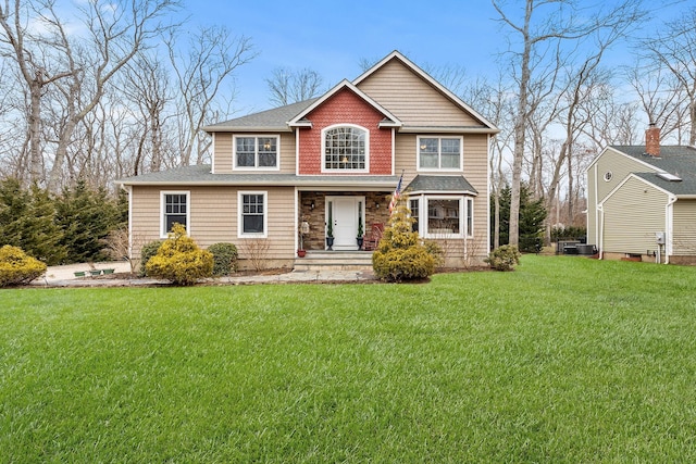 view of front of house featuring central AC and a front lawn