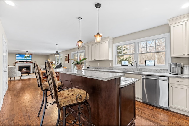380 Hickory Rd, Southold, NY 11971 - kitchen with a warm lit fireplace, a sink, dishwasher, a kitchen breakfast bar, and open floor plan