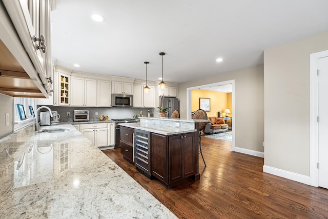 380 Hickory Rd, Southold, NY 11971 - kitchen featuring light stone countertops, wine cooler, a breakfast bar area, stainless steel appliances, and a sink