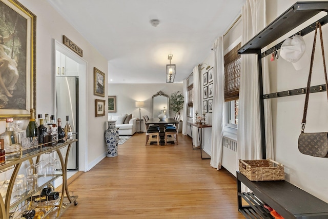 hallway featuring baseboards and light wood finished floors