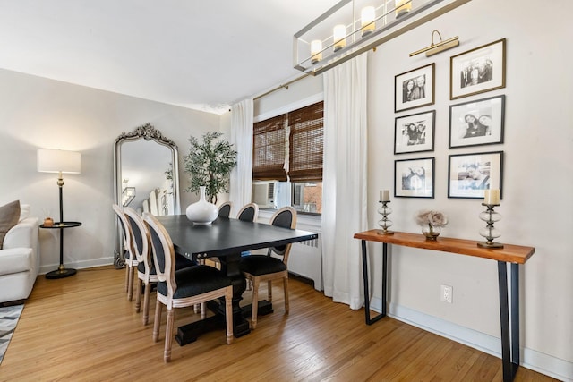 dining room with cooling unit, a chandelier, baseboards, and light wood-style flooring