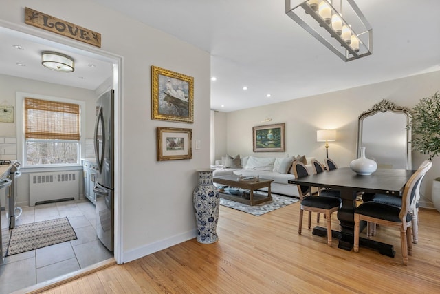 dining room featuring light wood finished floors, recessed lighting, radiator, and baseboards