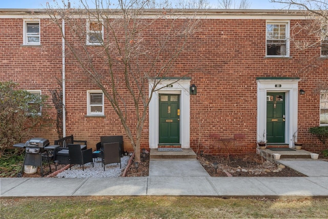 view of front facade with brick siding and entry steps