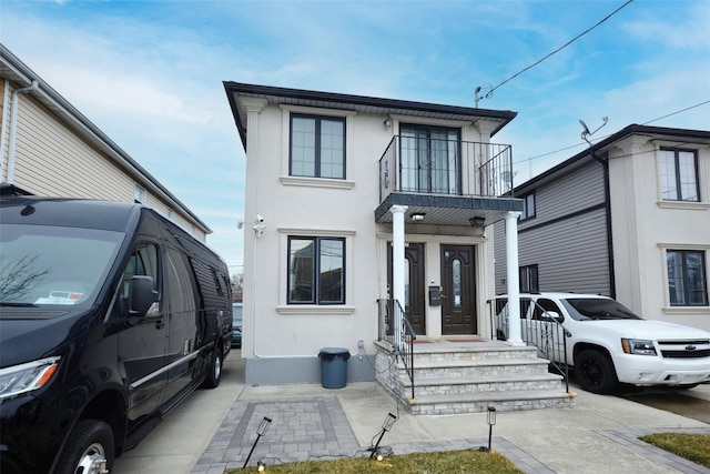 view of front of property featuring a balcony and stucco siding