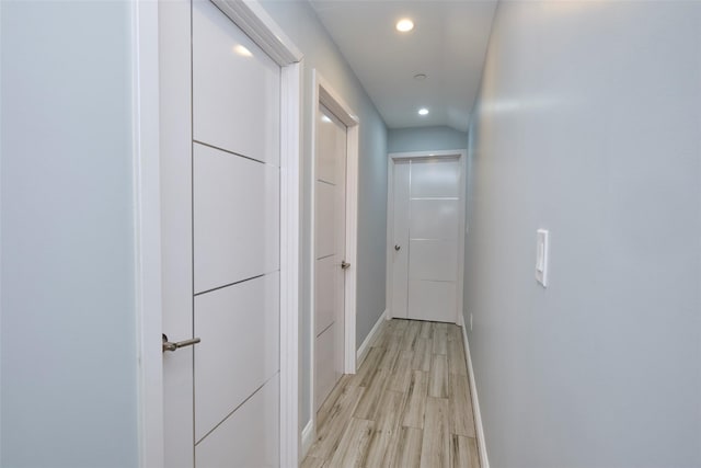 corridor featuring recessed lighting, light wood-type flooring, and baseboards