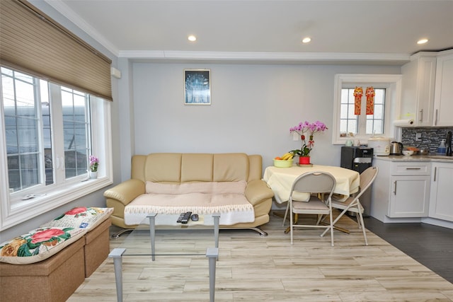 living area featuring light wood finished floors, ornamental molding, and recessed lighting