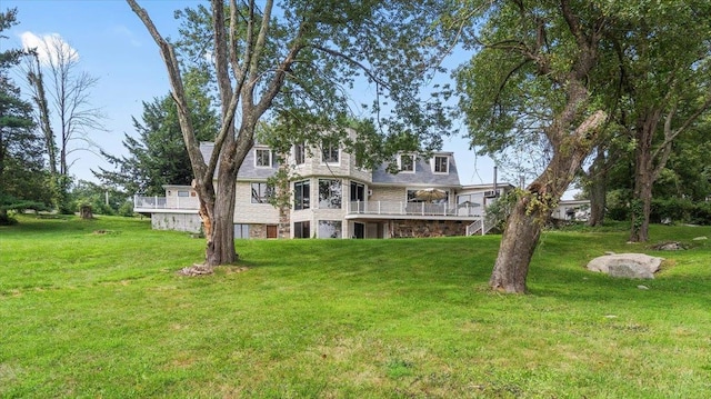 rear view of house with a lawn and a deck