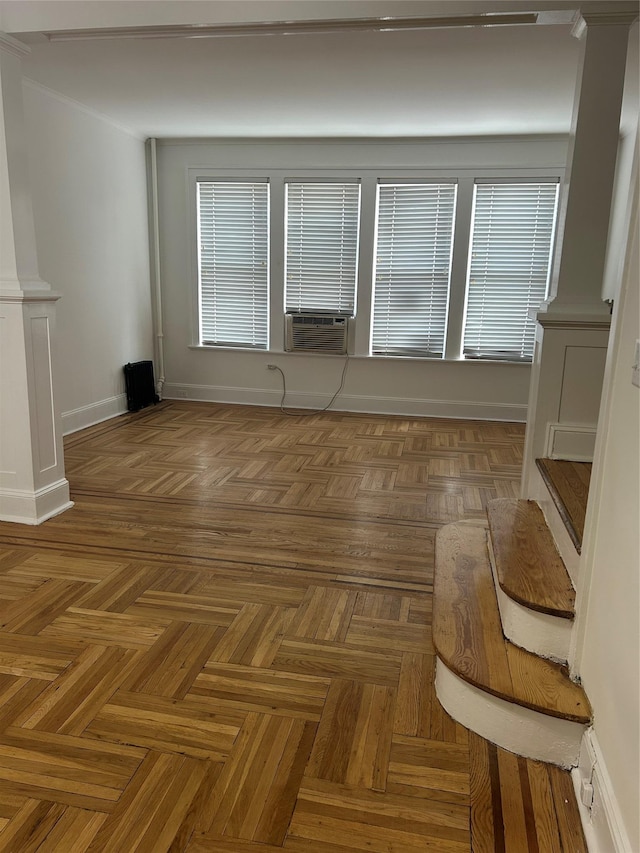 spare room featuring decorative columns, baseboards, and cooling unit