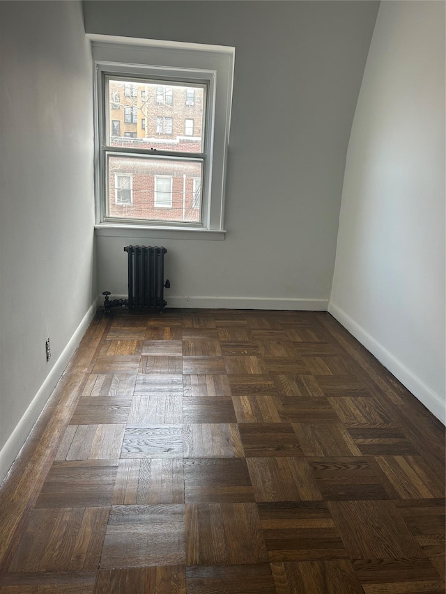 spare room featuring baseboards and radiator heating unit