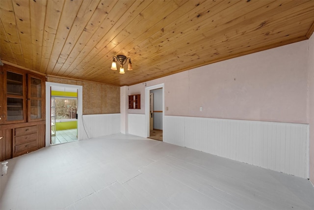 unfurnished room with a wainscoted wall and wooden ceiling