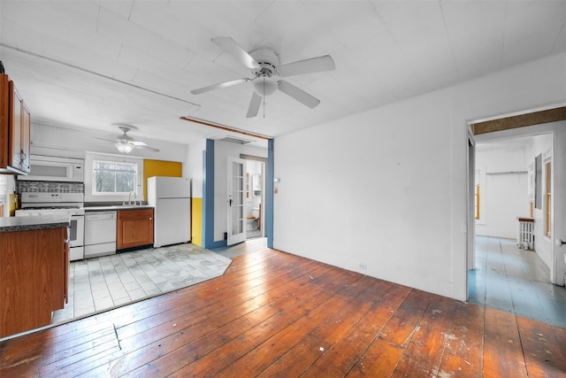 kitchen featuring brown cabinets, ceiling fan, white appliances, and light wood finished floors