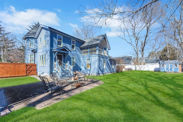 back of property with an outbuilding, a patio, a fenced backyard, a yard, and a shed