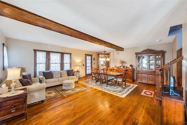 living area featuring beam ceiling and wood finished floors