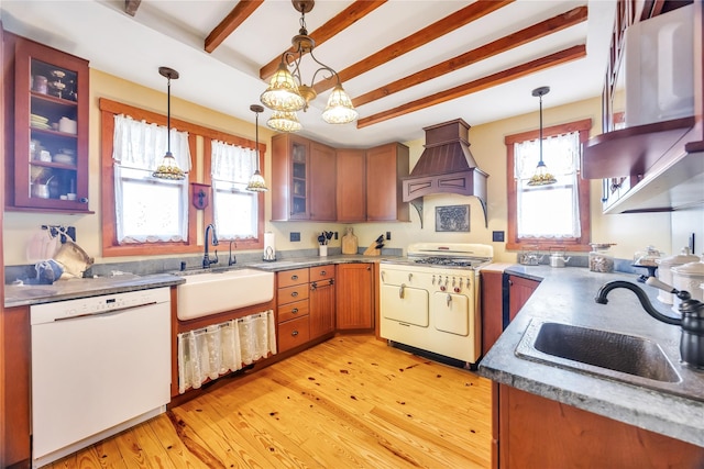 kitchen with dishwasher, custom exhaust hood, a sink, and gas range