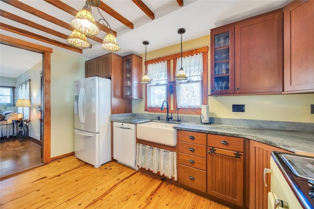 kitchen with white appliances, a sink, light wood-style flooring, and beam ceiling