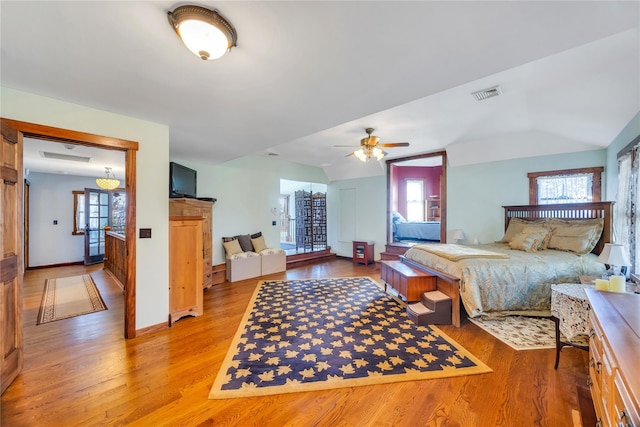 bedroom featuring visible vents, vaulted ceiling, and light wood-style flooring