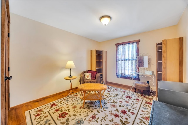 sitting room featuring baseboards and wood finished floors