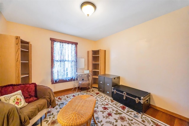 living area with baseboards and wood finished floors