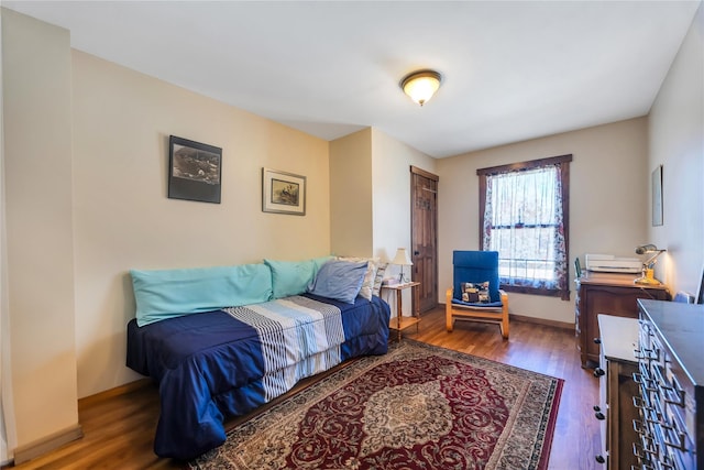 bedroom with baseboards and wood finished floors