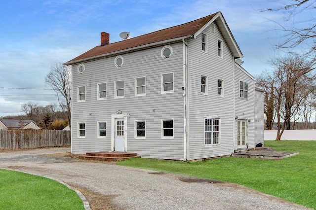 rear view of property with a yard, a chimney, a patio area, and fence