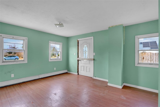 entryway with a baseboard radiator, baseboards, and wood finished floors