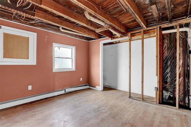 below grade area with baseboard heating and wood finished floors