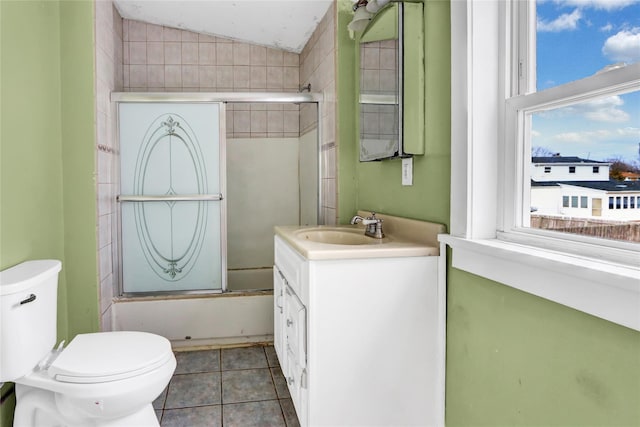 bathroom with toilet, combined bath / shower with glass door, vaulted ceiling, vanity, and tile patterned floors