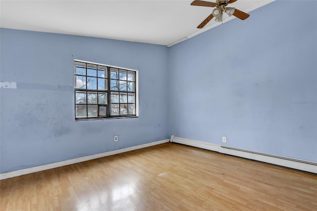 empty room featuring a baseboard radiator, ceiling fan, and wood finished floors