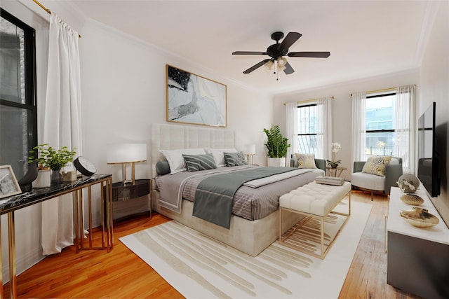 bedroom with ornamental molding, ceiling fan, and light wood-style flooring