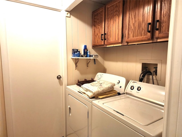 clothes washing area featuring cabinet space and independent washer and dryer