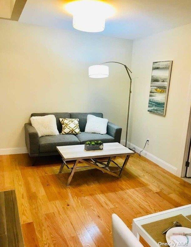 living room featuring light wood-type flooring and baseboards