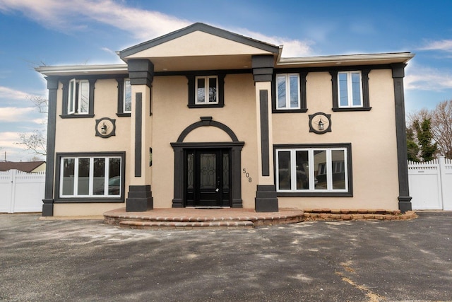 view of front of house with fence and stucco siding