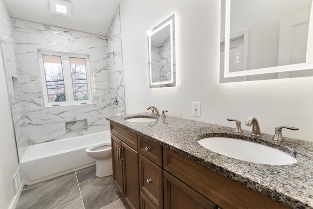 bathroom featuring visible vents, double vanity, a sink, and toilet