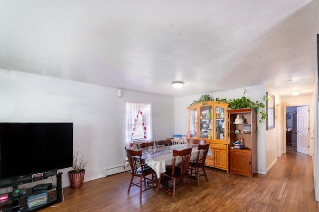 dining space with baseboards, baseboard heating, and wood finished floors