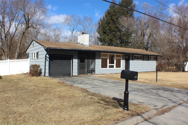 single story home with a garage, fence, driveway, a chimney, and a front yard