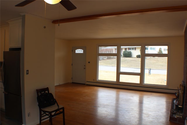 unfurnished living room with a baseboard radiator, wood finished floors, and ceiling fan