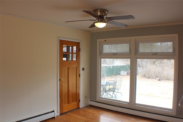 foyer with a wealth of natural light, light wood-style flooring, a baseboard heating unit, and a baseboard radiator